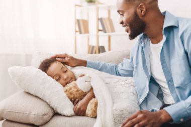 Yardımsever baba uyuyan kızı, yakın oturan bakarak