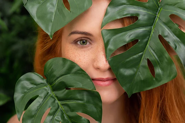 Portret van jonge en mooie vrouw in tropische bladeren — Stockfoto