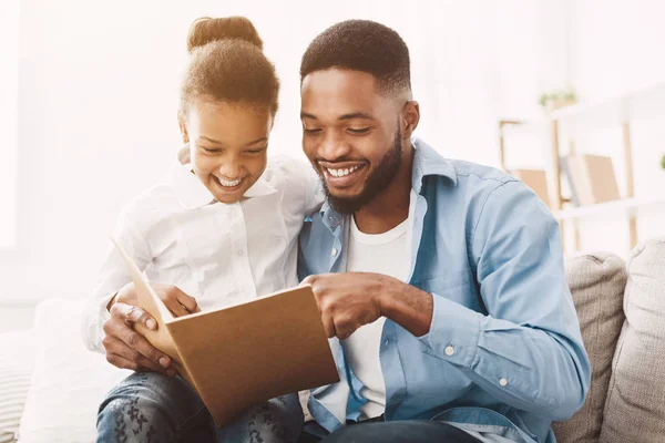 Niña y padre disfrutando leyendo el libro juntos — Foto de Stock