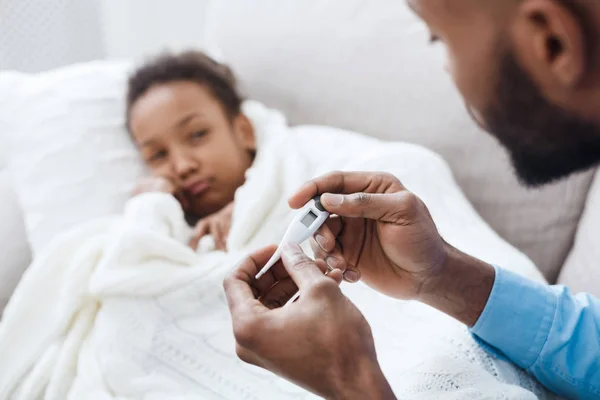 Pai medir a temperatura de sua filha doente — Fotografia de Stock