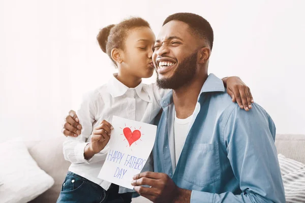 Feliz hija besando a papá y dando tarjeta de felicitación — Foto de Stock