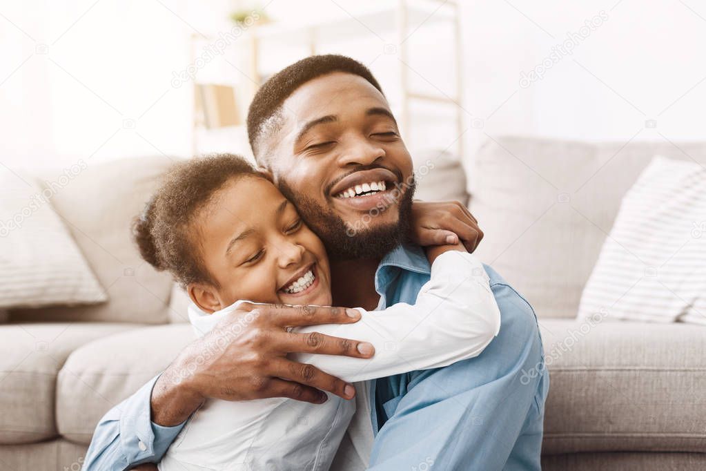 Adorable daughter hugging father with love and tenderness