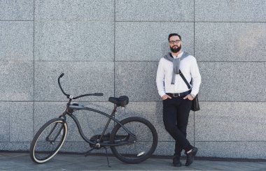 Duvar onun bisiklet ile inşa karşı ayakta işadamı.