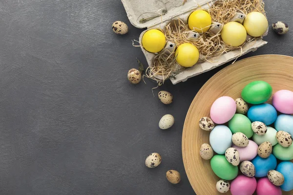 黑色桌子上的彩色复活节和鹌鹑蛋 — 图库照片