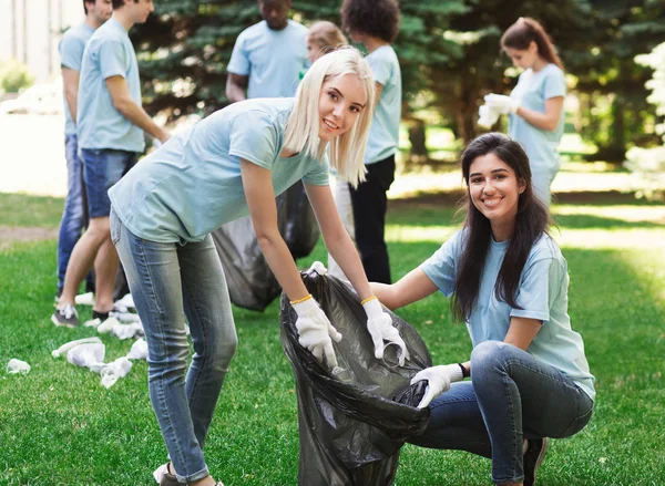 Vrijwilligers voor het verzamelen van recyclebaar plastic flessen in park — Stockfoto