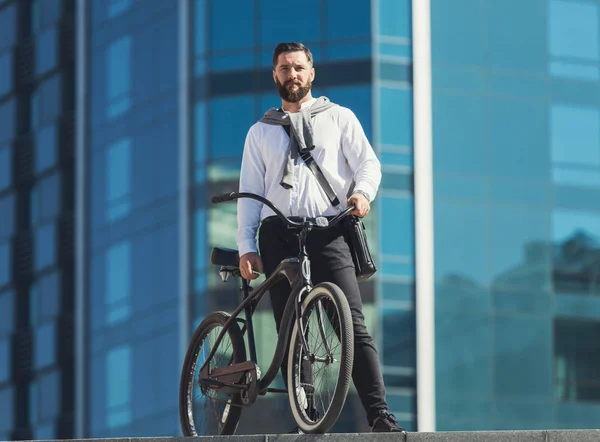 Homem de negócios barbudo carregando sua bicicleta nas escadas — Fotografia de Stock