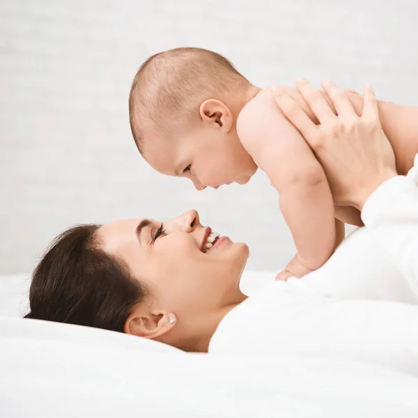 Мати з дитиною на ліжку добре проводить час — стокове фото