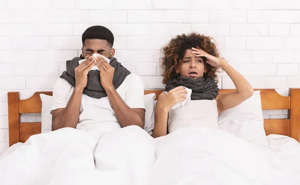 아픈 아프리카계 미국인 부부 침대에서 코를 불고 — 스톡 사진