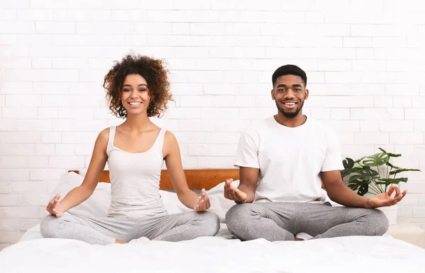 Jovem família negra meditando na cama juntos — Fotografia de Stock