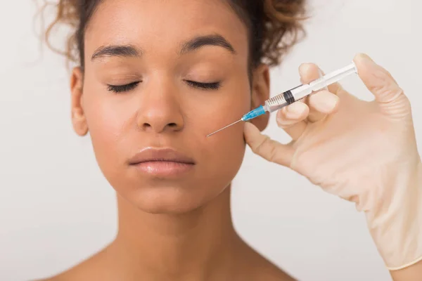 African-american woman getting face injection in clinic — Stock Photo, Image