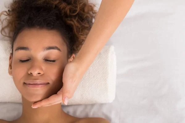 Mujer afroamericana recibiendo masaje facial en salón de belleza —  Fotos de Stock