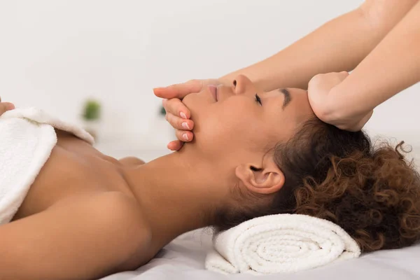 Afro-Amerikaanse meisje geniet gezicht massage in de spa salon — Stockfoto