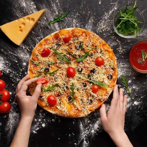 Chef dekoriert Pizza mit Kirschtomaten, Ernte — Stockfoto