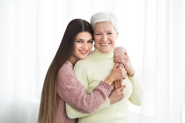 Feliz mamá e hija mayores abrazándose en casa — Foto de Stock