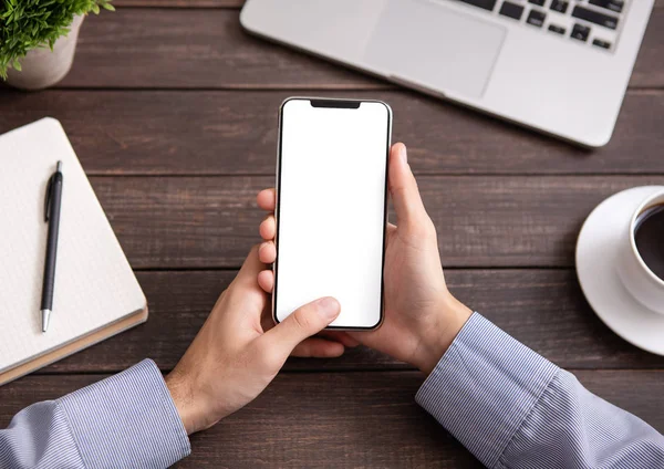 Hombre usando teléfono inteligente en blanco en el escritorio del lugar de trabajo —  Fotos de Stock