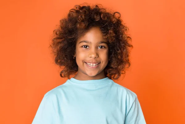 Portret van schattige Afro-Amerikaanse kind meisje over oranje achtergrond — Stockfoto