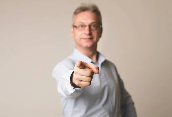 Senior-Geschäftsmann zeigt mit dem Finger auf Kamera über Hintergrund — Stockfoto