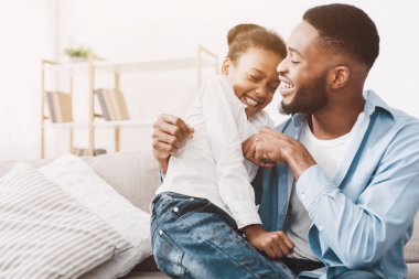 Baba ve kızı evde birlikte oynuyorlar.