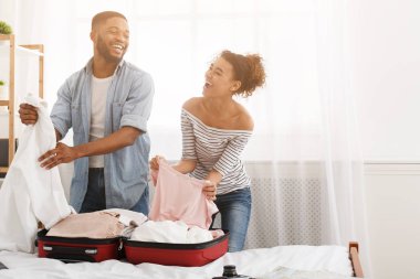 Mutlu çift bavul giysi paketleme, balayı için hazırlanıyor