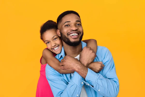 Little girl hugging father, having fun over background — Stock Photo, Image