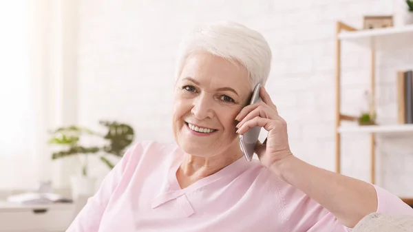 Femme âgée parlant sur son téléphone portable à la maison — Photo