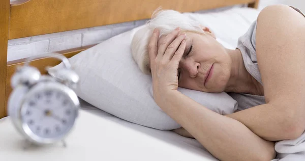 SEnior mujer que sufre de insomnio en la cama — Foto de Stock