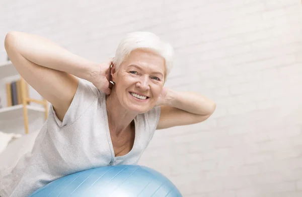 Mulher madura feliz fazendo exercícios com bola de fitness — Fotografia de Stock
