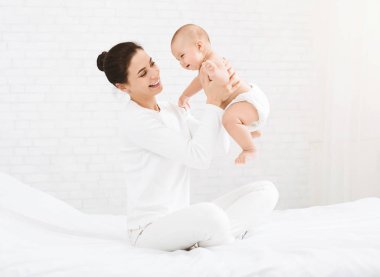 Genç Anne mutlu bebeği havaya kaldırmış