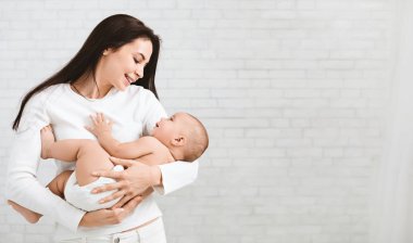 Genç Anne şirin yeni doğmuş çocuğunu sarılma