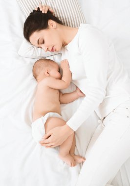 Genç Anne ve yatakta uyuyan sevimli bebek