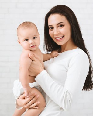 Genç Anne şirin yeni doğmuş çocuğunu sarılma