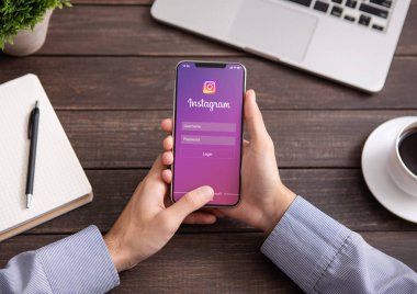 İPhone ack Instagram uygulama ile ekranda tutan adam.