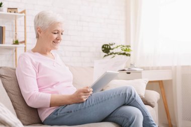 Belgeler ve dijital tablet ile çalışan üst düzey kadın
