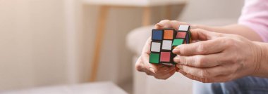 Yaşlı Rubiks küp tutarak ve iskambil ile o kadın