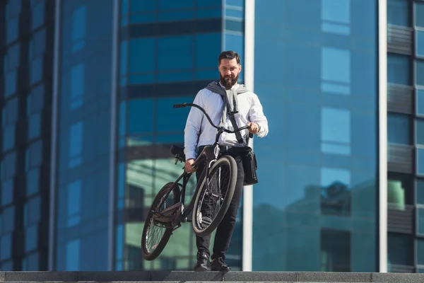 Bonito homem de negócios carregando sua bicicleta enquanto vai em escadas — Fotografia de Stock