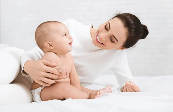 Mamma leker med hennes baby i sovrum. — Stockfoto