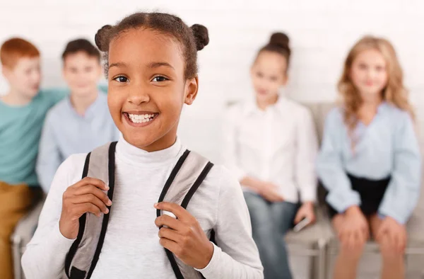 African-american school girl with classmates on background