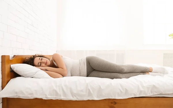 Schöne junge Frau schläft in ihrem Bett liegend — Stockfoto