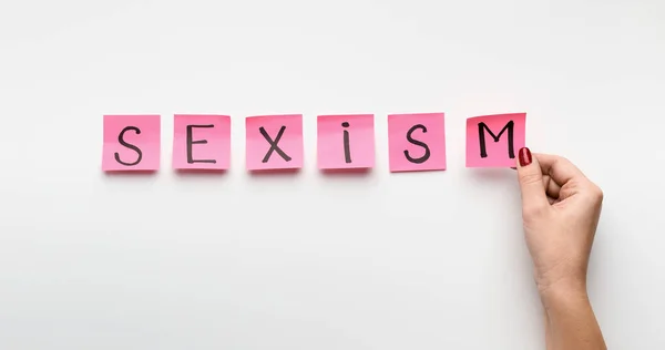 字性别歧视写在粉红色的办公室贴纸 — 图库照片