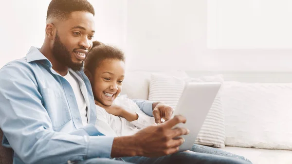 Отец и дочь играют на цифровом планшете — стоковое фото