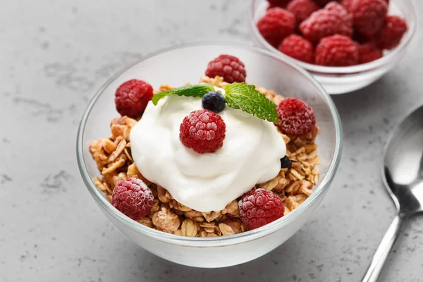 Granola, yougurt and raspberries in bowls — Stock Photo, Image