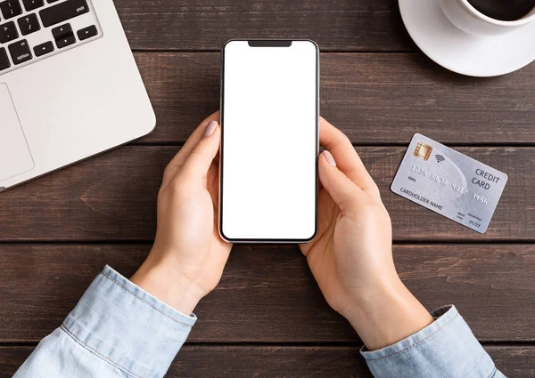 Mãos femininas segurando usando telefone celular com cartão de crédito — Fotografia de Stock