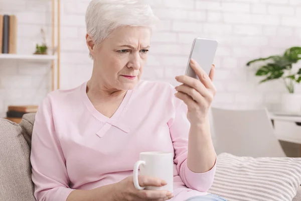 Seniorin mit Sehproblemen telefoniert — Stockfoto