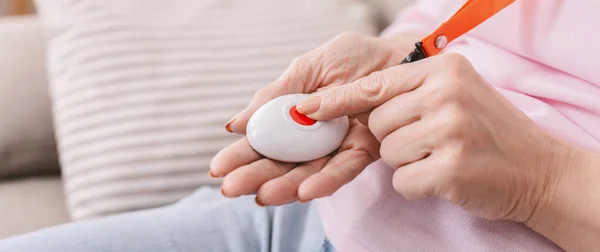 Ręka senior kobieta naciskając przycisk Alarm, zbliżenie — Zdjęcie stockowe