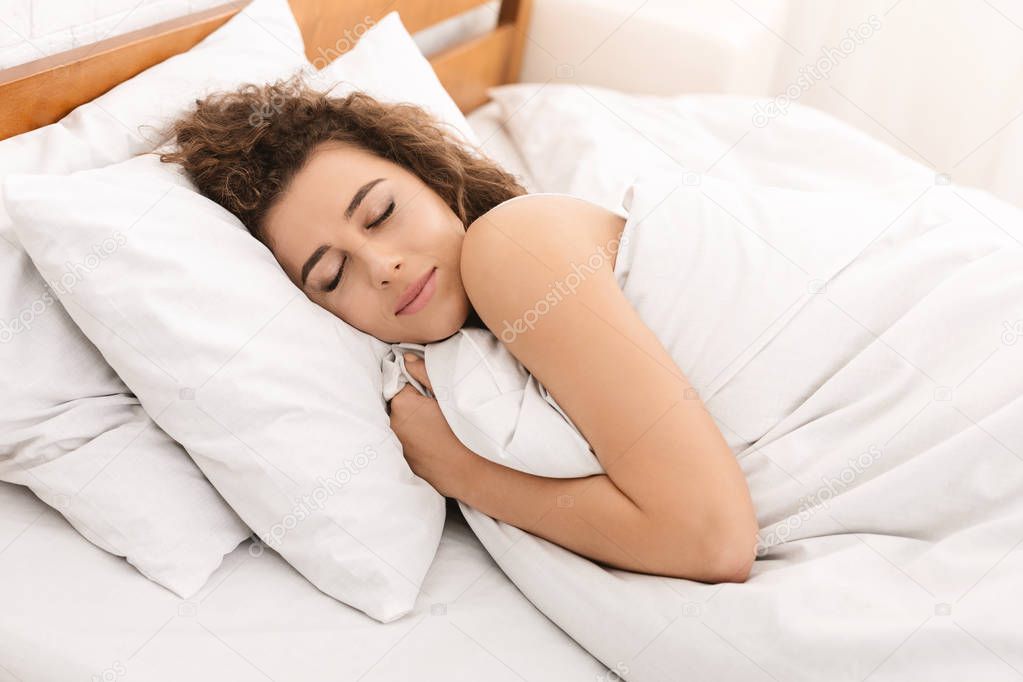 Young woman sleeping in bed in morning