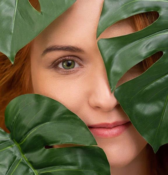 Portret van jonge en mooie vrouw in tropische bladeren — Stockfoto