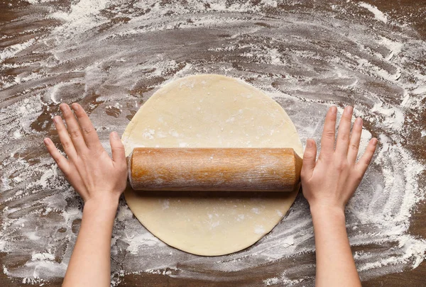 Приготування тістечка. Жінка котиться тісто, вид зверху — стокове фото