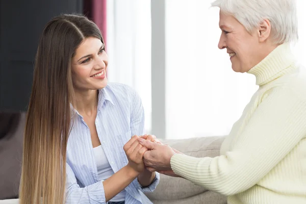 Unterstützung durch die Familie. Tochter hält Mutter die Hände und redet — Stockfoto