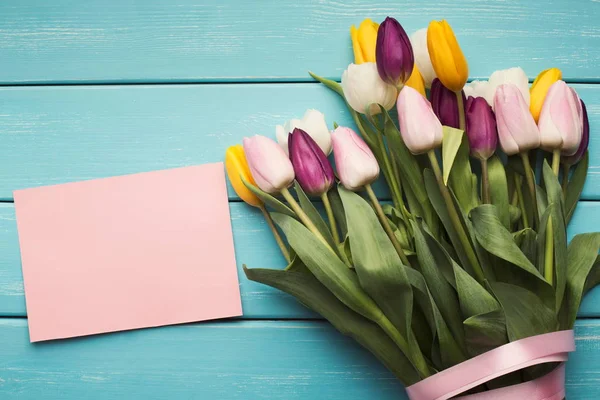 Барвисті тюльпани та вітальна листівка на синьому фоні, копіювання простору — стокове фото
