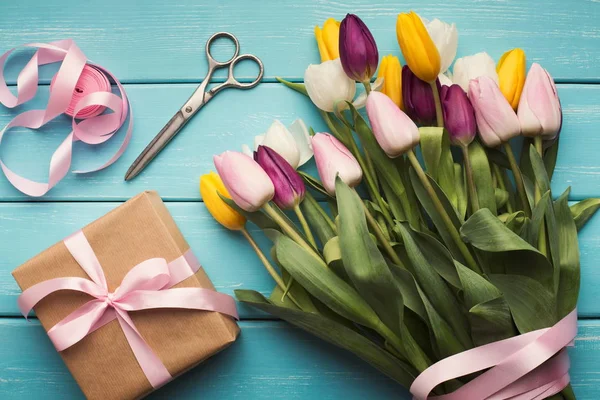 Kolorowe tulipany bukiet i dar pole na niebieskim tle drewnianych — Zdjęcie stockowe